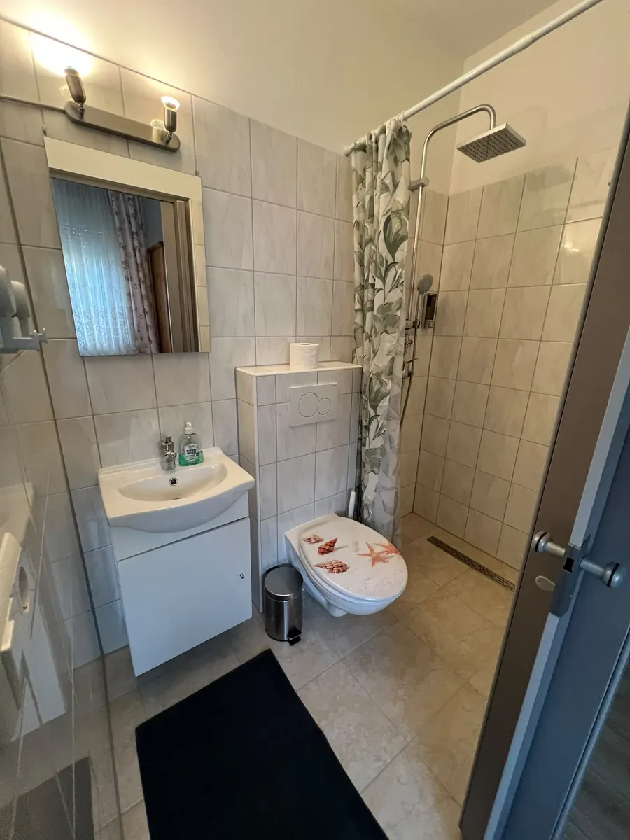 Bad mit ebenerdiger Dusche und Spiegelleuchte