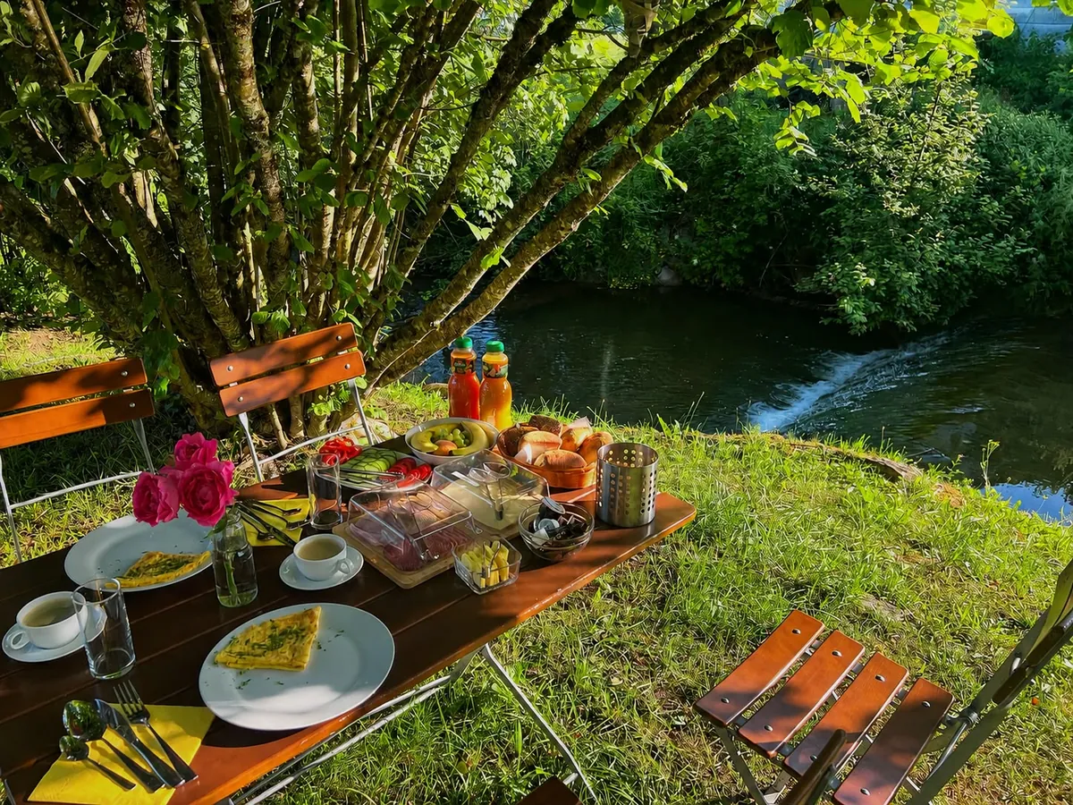Gedeckter Frühstückstisch im Garten direkt am Heimbach