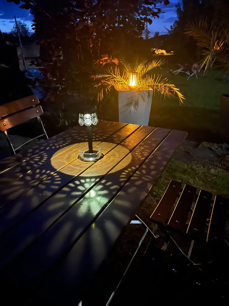 Gartentisch mit Windlicht in der Abenddämmerung