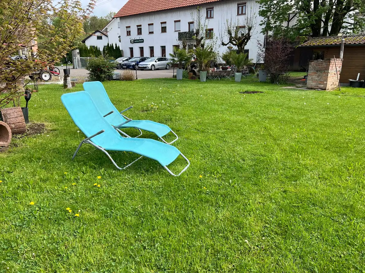 Sonnenliege auf der Gartenwiese vor dem Haus