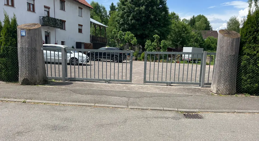 Das verschließbare Tor zum Parkplatz, seitlich eingezäunt