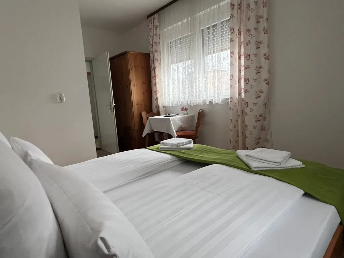 Doppelzimmer mit Kleiderschrank und Blick zum Fenster