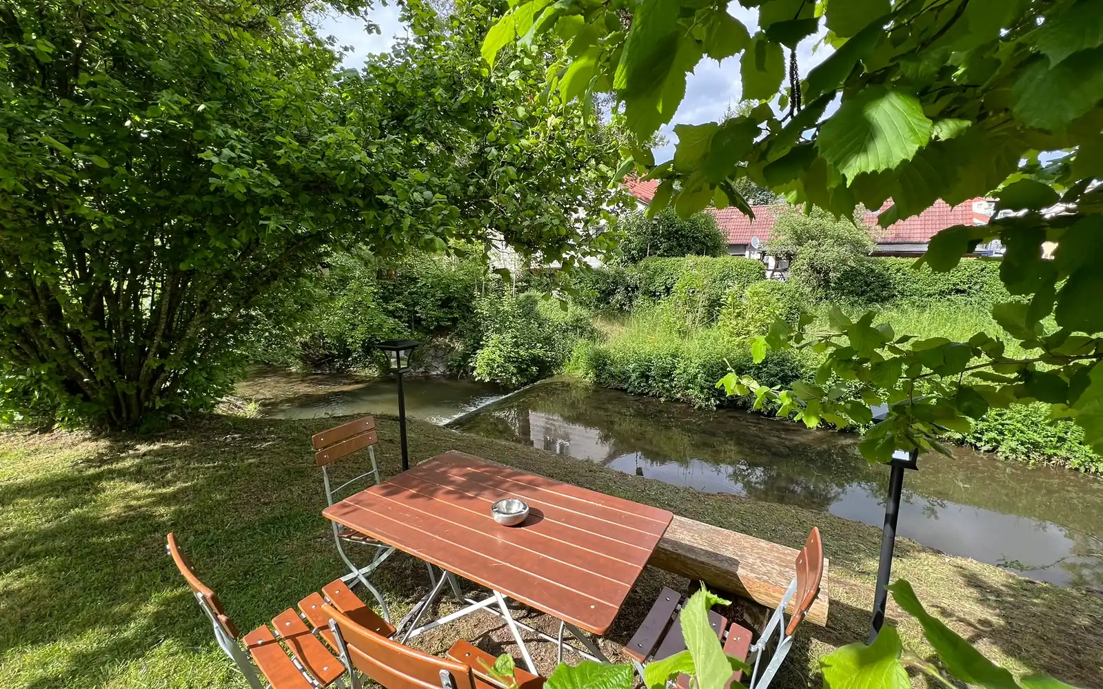 Gartentisch am Heimbach unter alten Bäumen