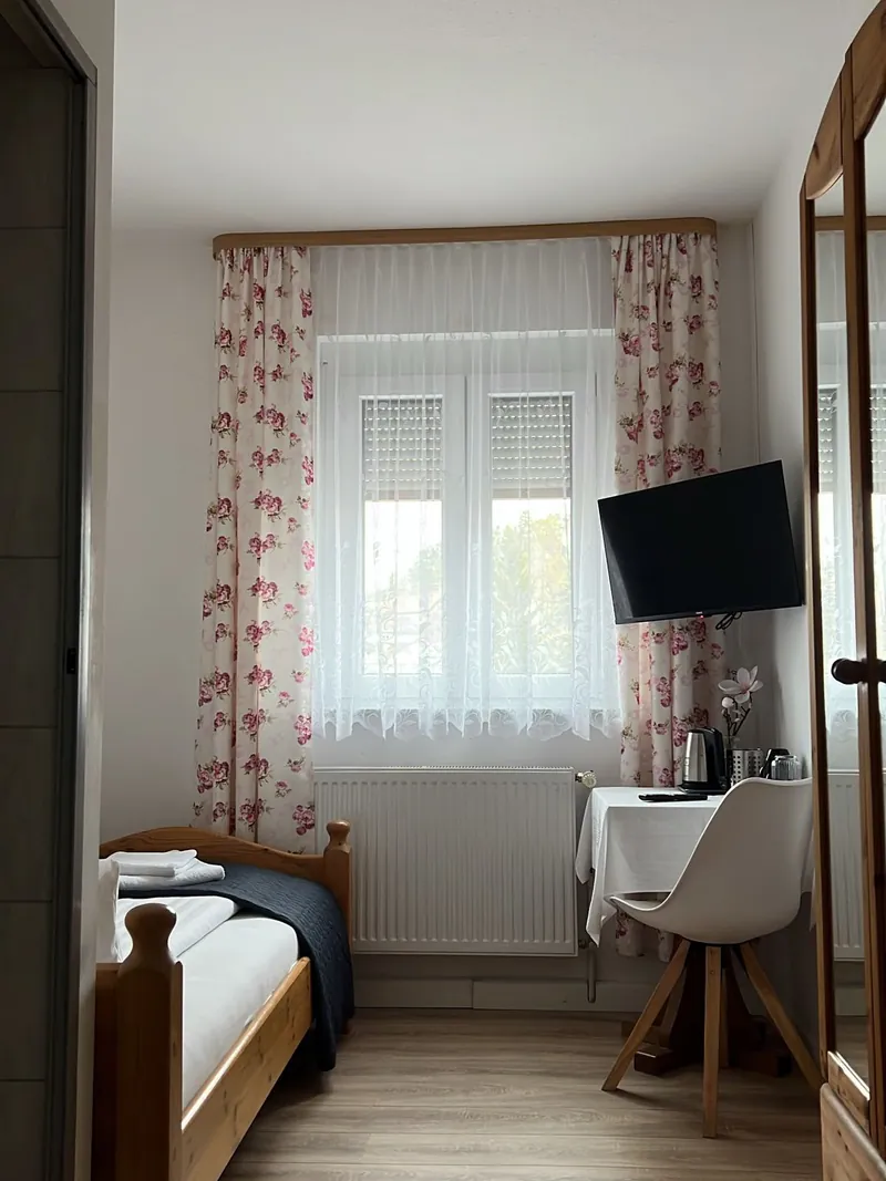 Zimmer mit Bett, Schreibtisch und TV fuer längere Aufenthalte
